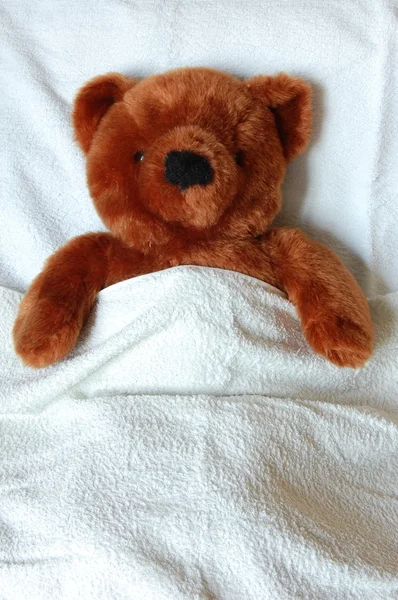 Больной Тедди с травмой в постели — стоковое фото