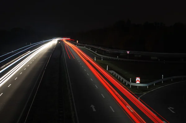 Route avec circulation automobile la nuit avec des feux flous — Photo