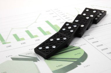 Risky domino over a financial business chart clipart