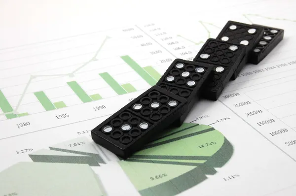 Domino arriscado sobre um gráfico de negócios financeiros — Fotografia de Stock