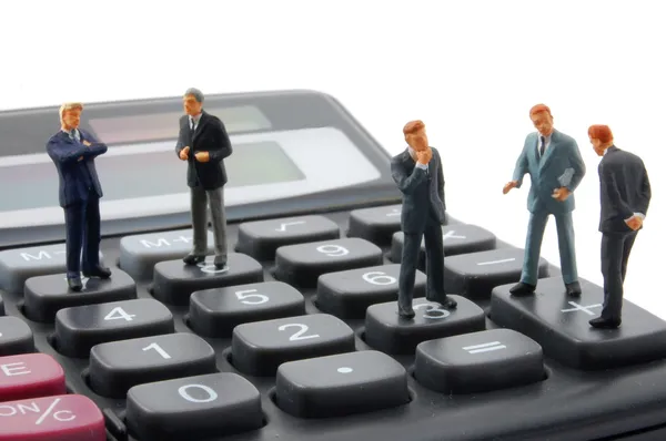 Toy business man on calculator isolated — Stock Photo, Image