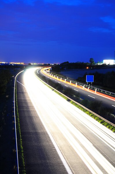 Night time traffic on highway with lights showing transportation concept