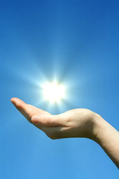 Рука солнце и голубое небо — стоковое фото