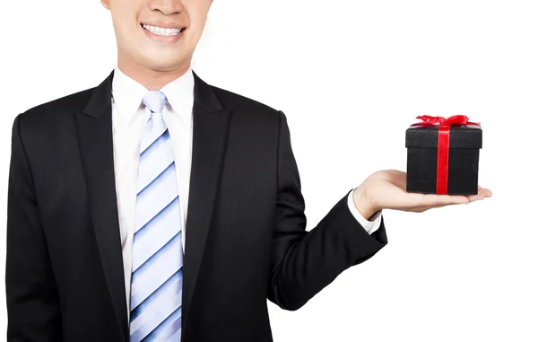 Smiling young man offering a gift — Stock Photo, Image