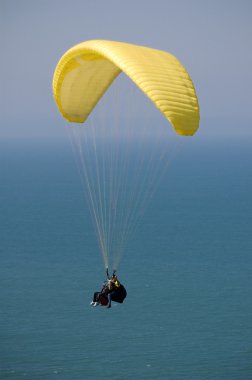 Double Paragliding above ocean clipart