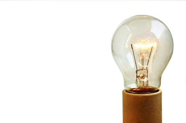 stock image Old light bulb on in a socket isolated