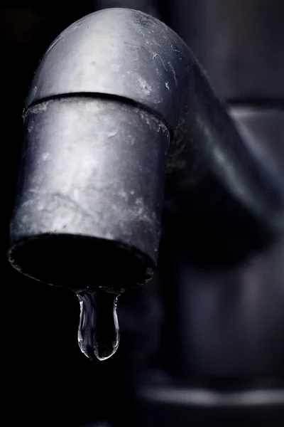 Vecchio rubinetto che perde attenzione sulla goccia d'acqua Fotografia Stock