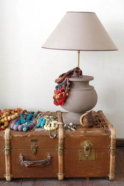 Lamp, beads and old suitcase on the floo — Stock Photo, Image