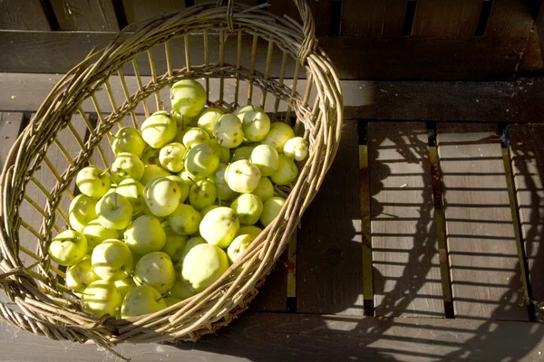 Appels in een mand met houttextuur achtergrond. — Stockfoto