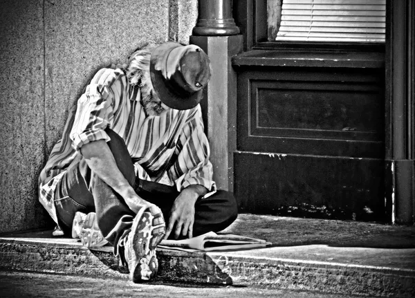 Portret van een dakloze man tegen een muur — Stockfoto