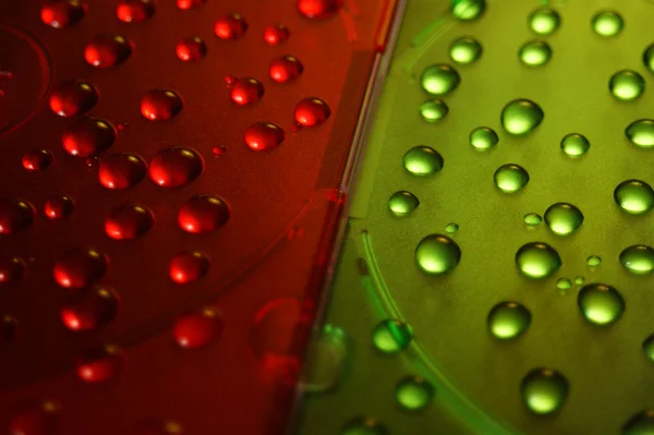 Gotas de agua sobre fondos verdes, rojos — Foto de Stock