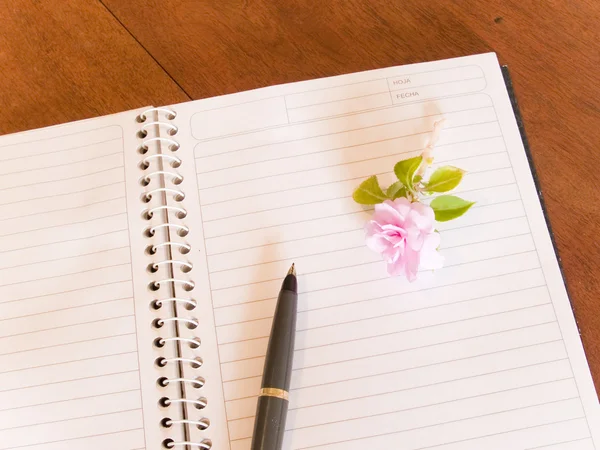 Блокнот, ручка і квітка — стокове фото