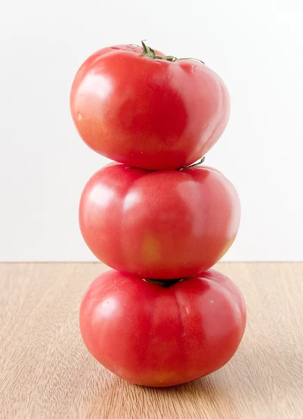 Три сложенных помидора — стоковое фото