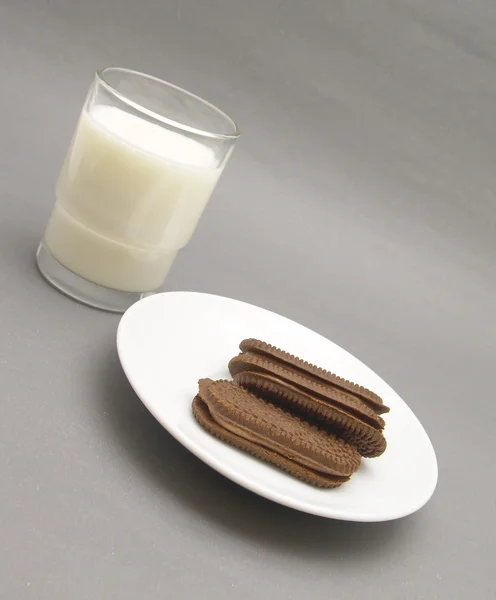 Склянка молока з шоколадним печивом — стокове фото