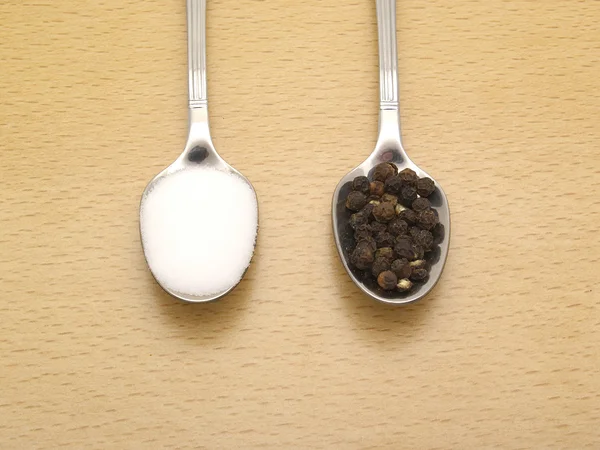 Spoons with salt and black pepper — Stock Photo, Image