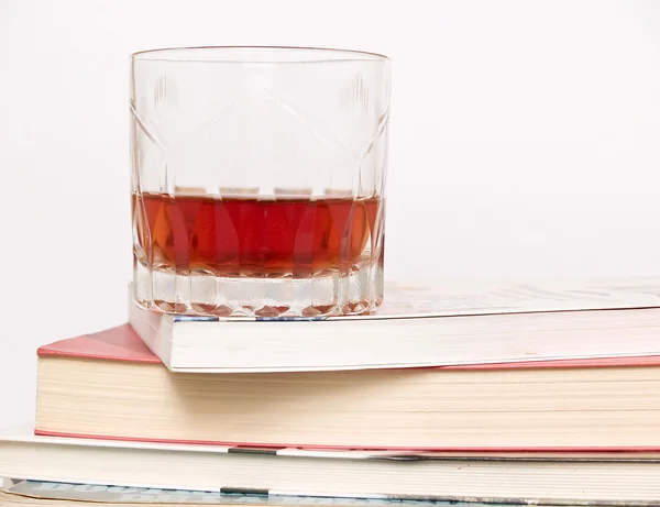 Glas whiskey på böcker — Stockfoto
