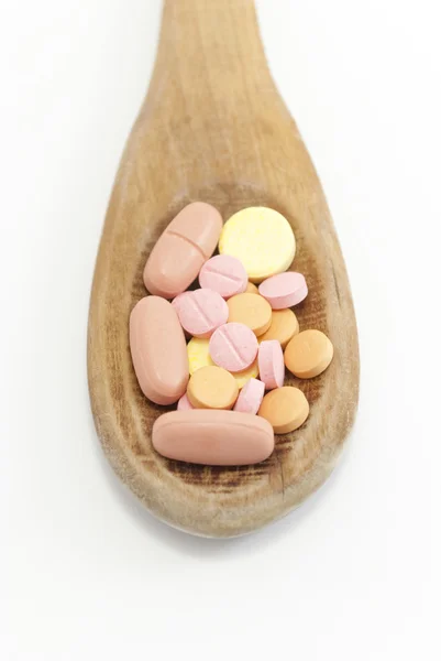 Cucchiaio di legno con pillole — Foto Stock