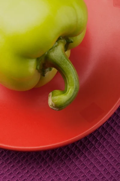 Grön paprika på en orange tefat — Stockfoto