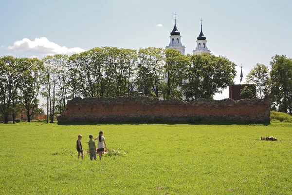 Three children on field by Livonia order castle ruins and church — Stock Photo, Image