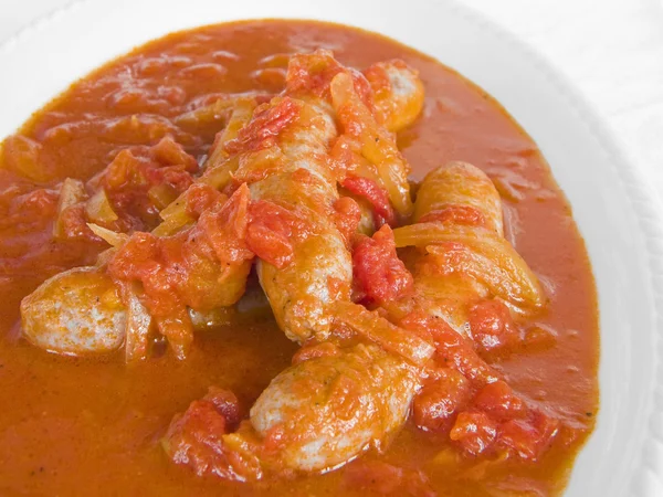 Sausages in tomato sauce on white dish. — Stock Photo, Image