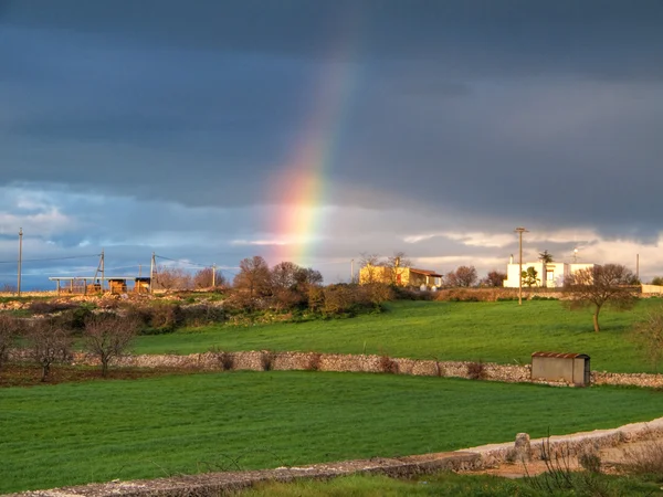 Regenboog in platteland. Apulië. — Stockfoto