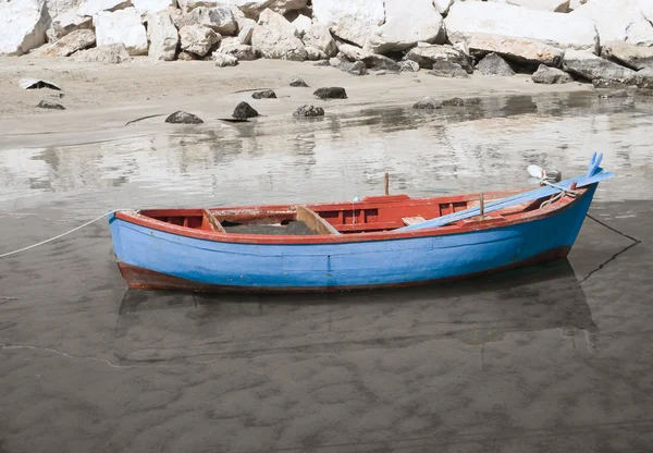 Barco de pesca na costa da praia arenosa . — Fotografia de Stock
