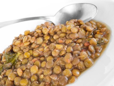 Lentil soup with spoon on white dish. clipart