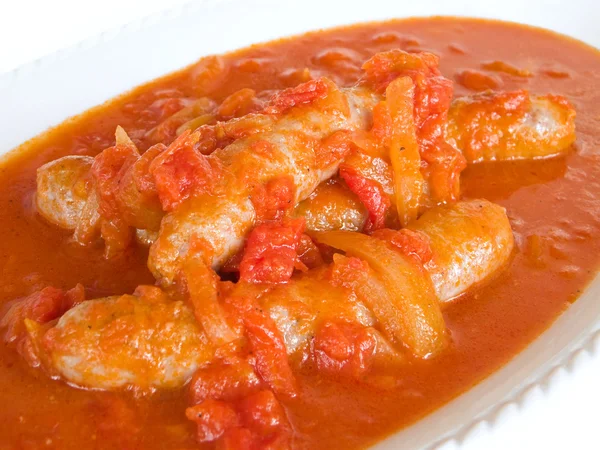 Sausages in tomato sauce on white dish. — Stockfoto