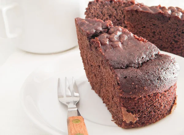 Schokoladenkuchenscheibe auf weißem Teller. — Stockfoto