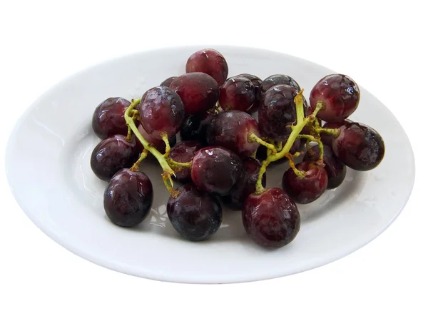 stock image Bunch of black grapes on a white dish.