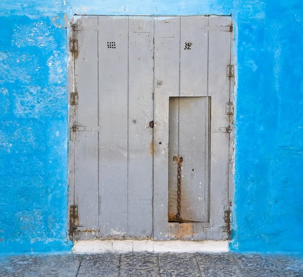 Деревянная дверь на голубой стене . — стоковое фото