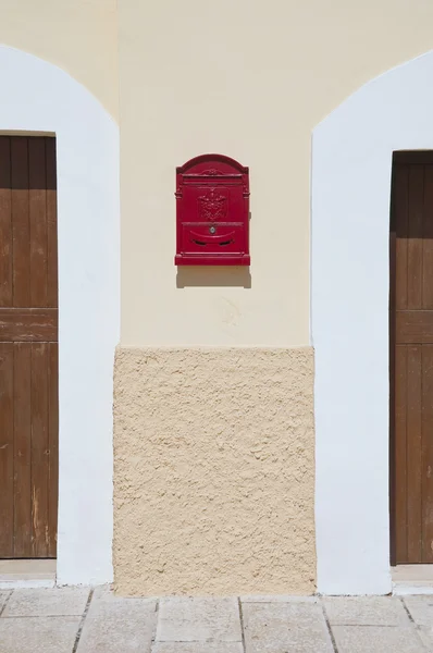 Red postbox between two doors. — Stock Photo, Image