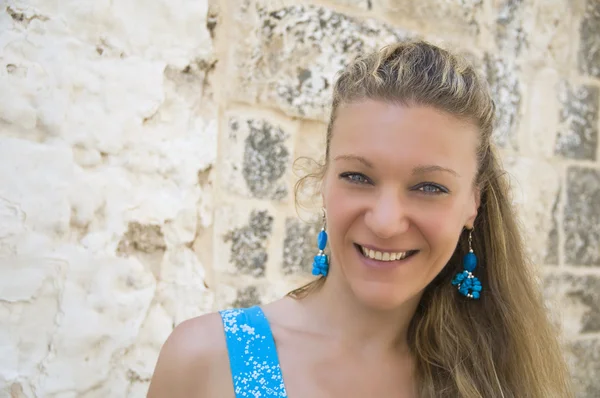 Lächelnde Frau mit türkisfarbenen Ohrringen. — Stockfoto