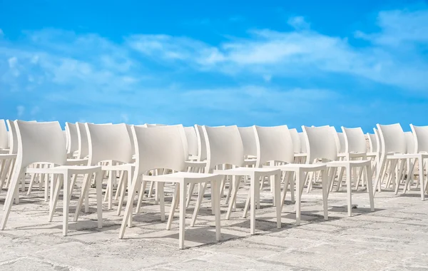 Mavi gökyüzü beyaz sandalye grubu. — Stok fotoğraf