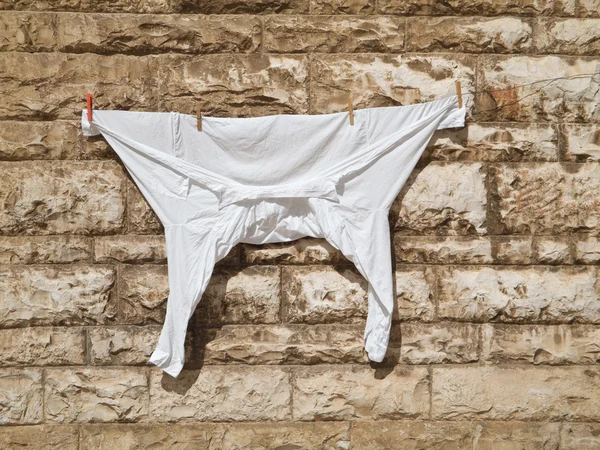 stock image White shirt hanging out on brickwall.