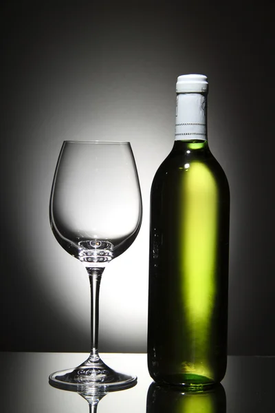 Bottle of white wine and empty wine glass — Stock Photo, Image
