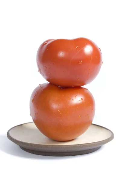 Два помидора на изолированной тарелке — стоковое фото