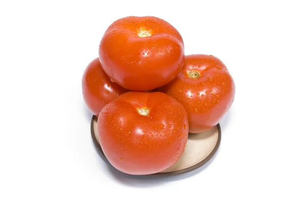 Четыре помидора на тарелке — стоковое фото