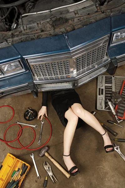 Жінка ремонтує свою машину — стокове фото