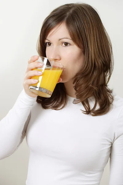 Beautiful female drinking orange juice — Stock Photo, Image