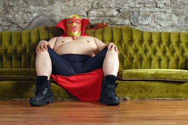 Mexican wrestler sitting on a couch clipart