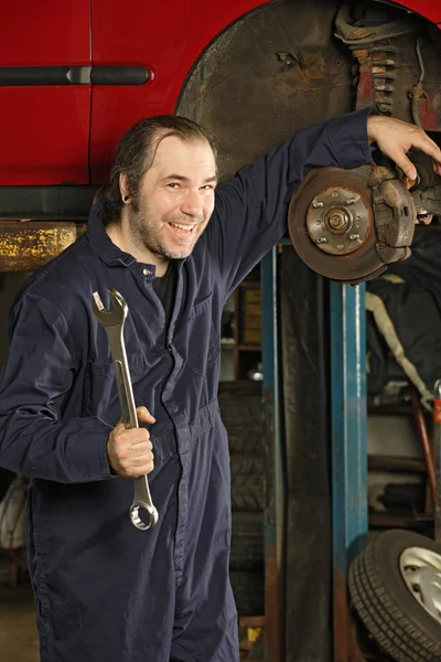 Verrückter Mechaniker, der die Bremsen repariert — Stockfoto