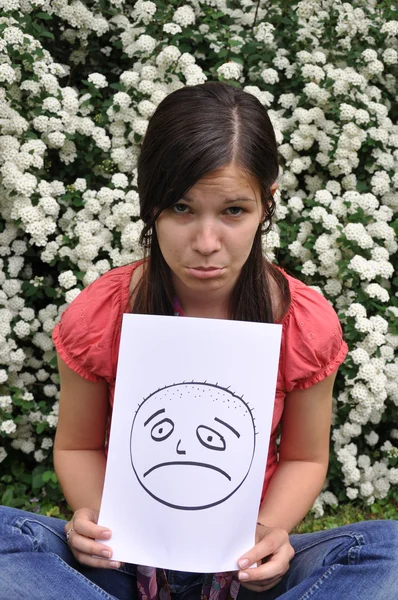 Üzgün kız parkta bir kağıt tutan — Stok fotoğraf