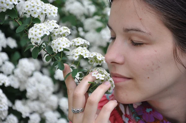 Young beautiful girl smells white flow — Stock Photo, Image