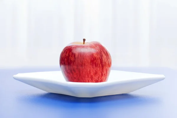 Apple in white plate — Stock Photo, Image