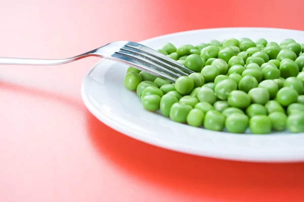 Guisantes verdes en plato —  Fotos de Stock