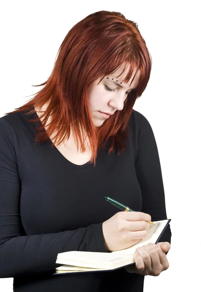 Cute redhead schrijven in haar notitieblok of dagboek — Stockfoto