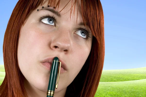 Söt tjej med penna på hennes läppar — Stockfoto