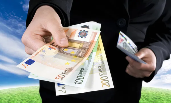 Hand giving Euro banknotes money — Stock Photo, Image