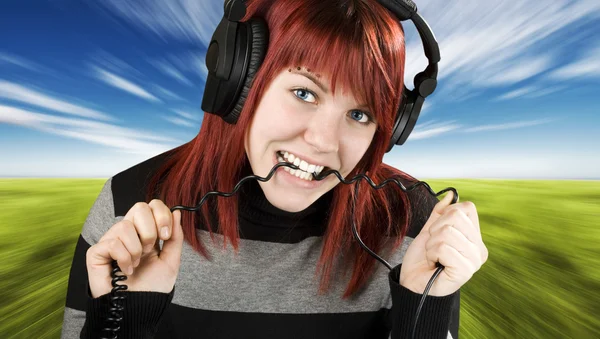 Chica mordiendo cable auriculares — Foto de Stock